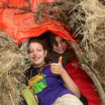 Suvival Camp campers celebrate in their debris hut.