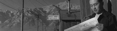 Roy Takeno reads a copy of the Manzanar Free Press. Photo by Ansel Adams.