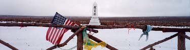 Cemetery monument with flag. NPS Photo.