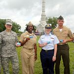 Photo of men and women in military uniform holding the new America the Beautiful military pass.