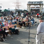 People on the pier enjoying a musical performance.