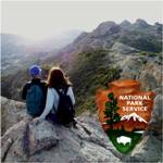 Two hikers enjoy a picturesque view from the top of the Santa Monica Mountains.