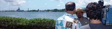 Daniel Martinez, USS Arizona Memorial Historian, conducts an interview with the memorial in background.