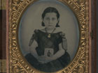 Photograph of a young girl holding a picture of a family member that has gone to war