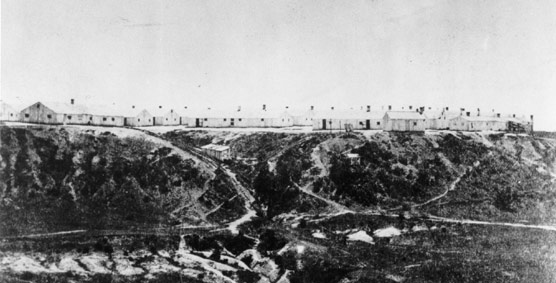 Historic image of Chimborazo hospital, with a series of white washed buildings at the top of a plateau.