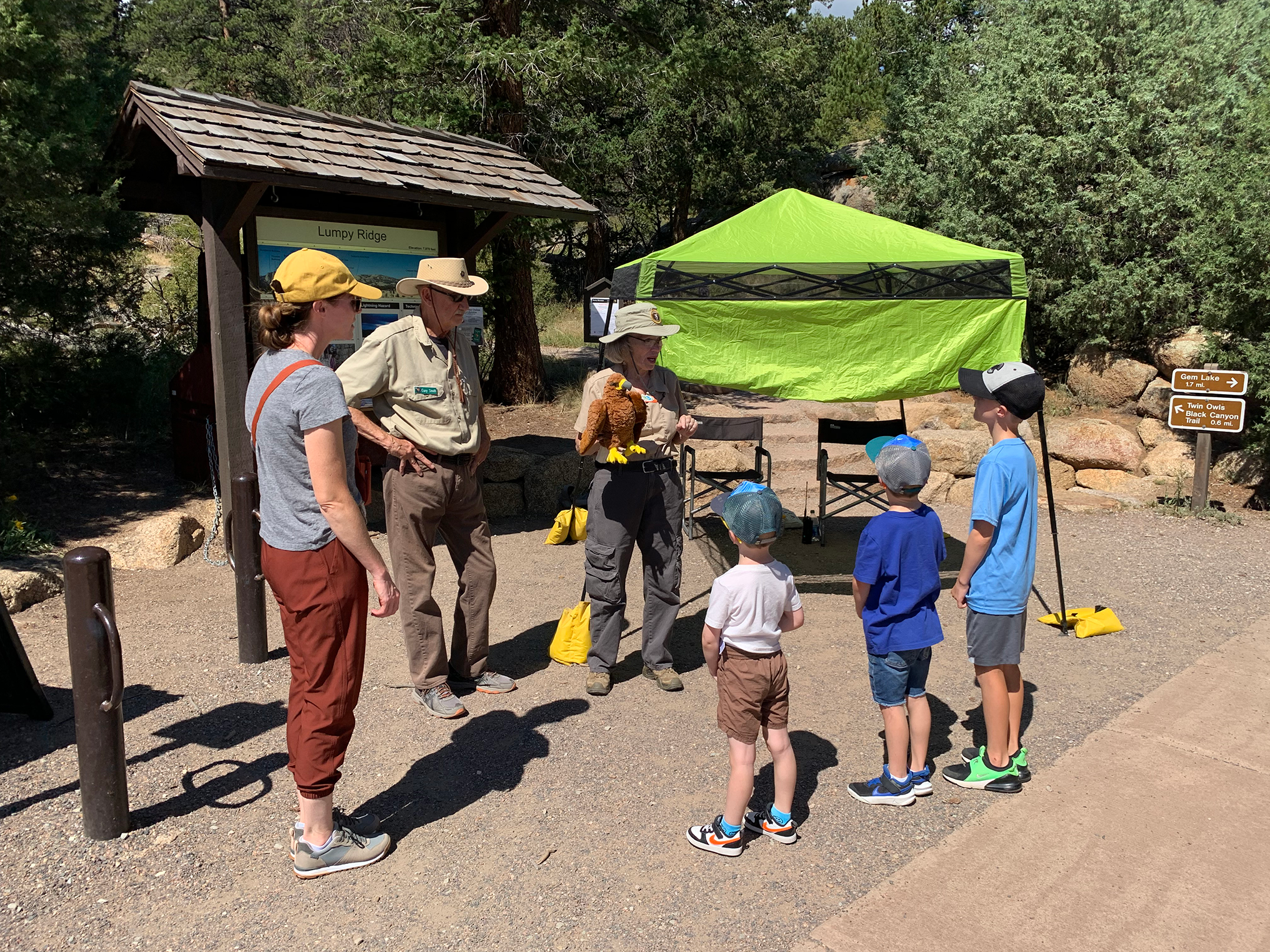 A raptor monitoring volunteer is educating visitors at Lumpy Ridge