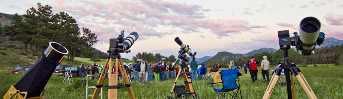 telescopes and people in a meadow