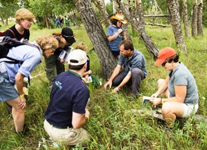 A scientist inventories vegetation with participants