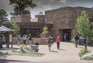 Photo of visitors strolling up the walkway to Beaver Meadows Visitor Center. 