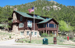 Photo of Moraine Park Visitor Center with the US flag flying out front. 