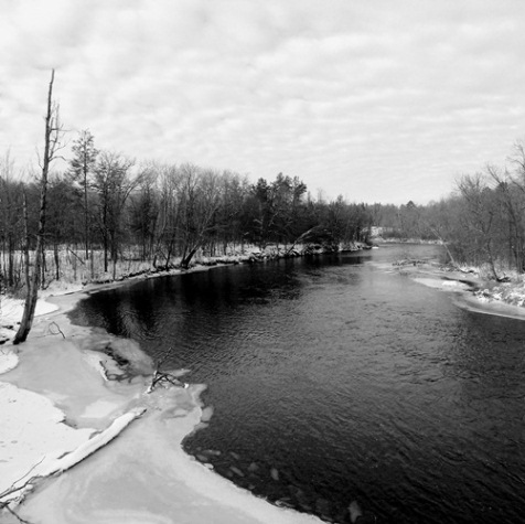 At a bend in the Namekagon River, thin ice lies between open water and a snow covered bank on a recent January day