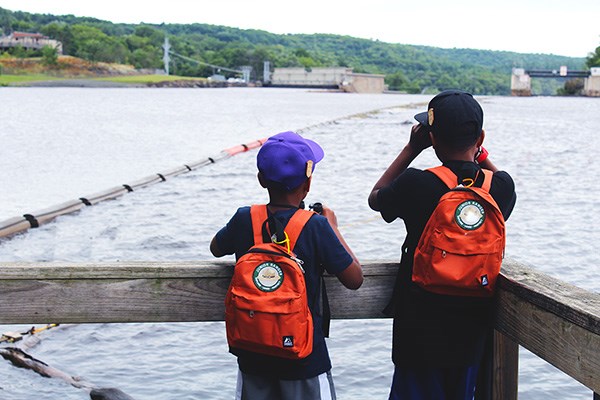 Two young boys using binoculars to look over the St. Croix River.