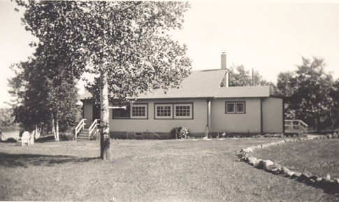 A dirt driveway leads to a small frame cabin along the St. Croix River