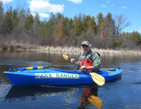 Park Ranger, Bob Downs, kayaks on the flowage above Gordon dam as part of an orientation trip. 