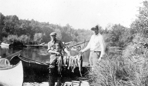 A historic photo of two friends displaying the days catch from the St. Croix. (Photo courtesy the Riegel Collection)
