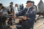 Volunteers and visitors work the capstan.