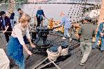 Visitors holding capstan bars turn the capstan.