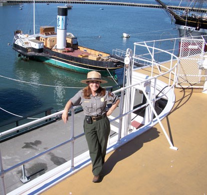 Teacher and Park Ranger Cynthia Harb standing on the deck of a ship at Hyde Street Pier.