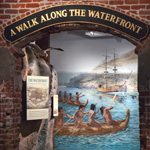The entryway to an exhibit in the park visitor center with the words A Walk Along the Waterfront in gold-colored lettering.
