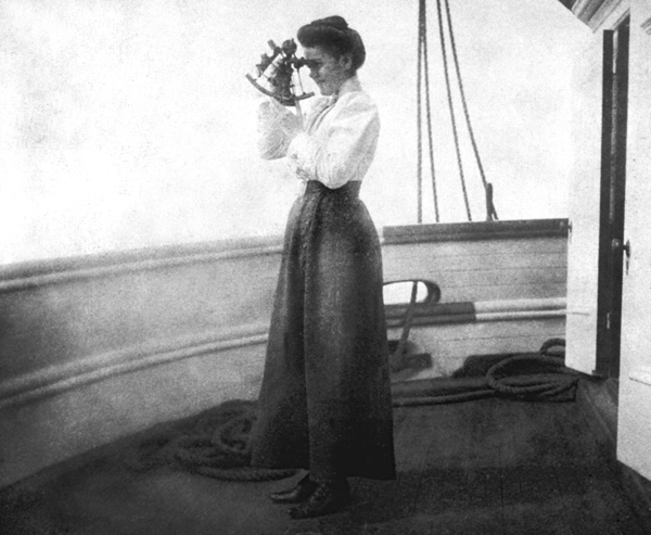 A woman standing on the deck of a ship and using a sextant.