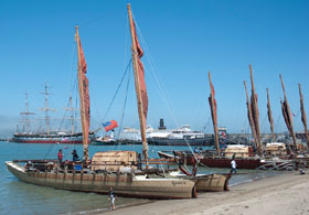 Voyaging vaka canoes lined up along the beach at San Francisco Maritime National Historical Park