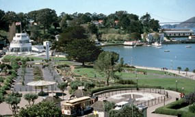 A view of the Aquatic park Historic District including the Maritime Museum, grass, beach and cove.