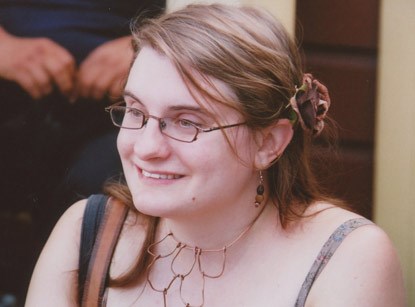 A woman wearing glasses and smiling.