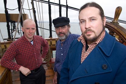 Three men standing on a ship.
