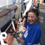 A woman smiling and holding a paintbrush on BALCLUTHA.