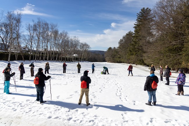 group of teacher stand in circle in snowy field