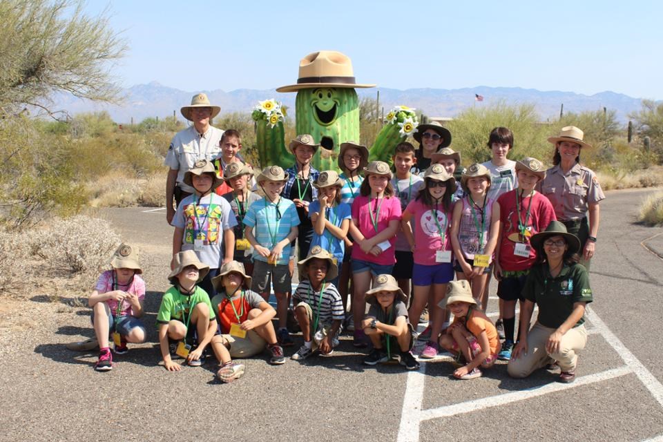 group of kids with large mascot cactus in background