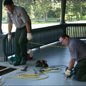Preservation workers rehabilitate sections of the front porch.