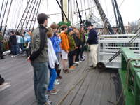 Students learn about simple machines by using lines and pulleys to raise and lower cargo.