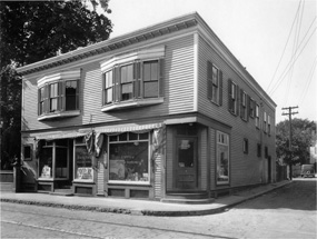 A two story building with bay windows on the second floor and storefronts on the first floor.