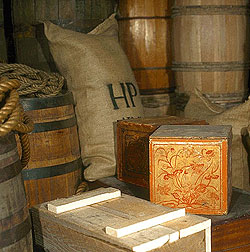 Boxes, bags, and barrels stacked in the Public Stores carried exotic goods