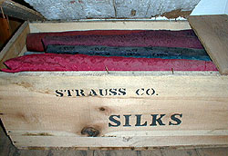 a box of brightly colored red, blue, and purple silk cloth
