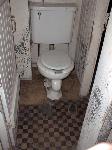 a toilet in a small room is the only bathroom