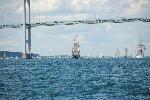 Tall ships sailing under a bridge