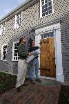 two men in front of an historic house