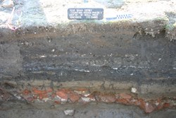 The layers of excavation, showing a clear layer of bricks.