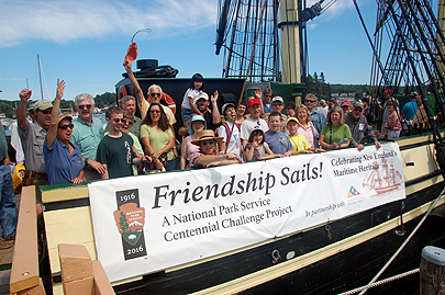 Volunteers and staff of Salem Maritime NHS wave from the deck of Friendship