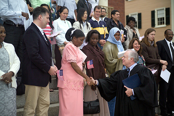 Judge Douglas Woodlock shakes hands with a new U.S. citizen