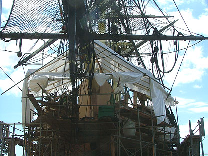 A view of Friendship from the ground, looking up at her bow and the tent-like cover put up over the workmen.