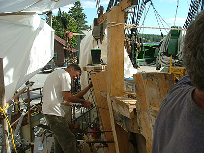 an oak upright timber at the front of the ship is being installed.