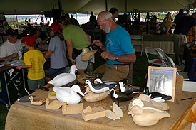 Decoy carver demonstrating stages in finishing decoys