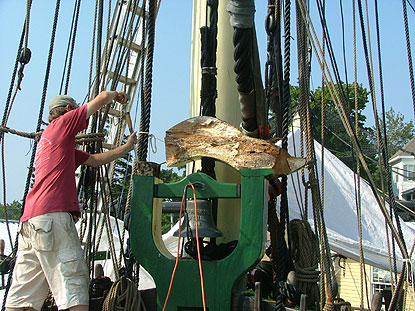 a volunteer removes the curved top to the belfry, which holds the ship's bell