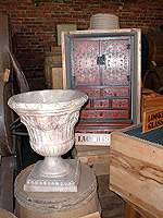 a white carved alabaster urn and a red and black lacquered cabinet in the public stores exhibit at Salem Maritime