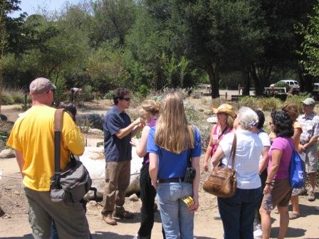 Teachers listen attentively as a botanist talks about the park's native plant garden.