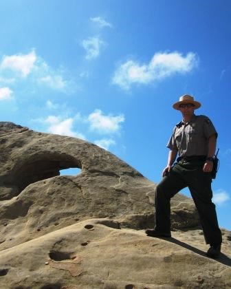 A park ranger stands next to an iconic rock formation at Castro Crest.