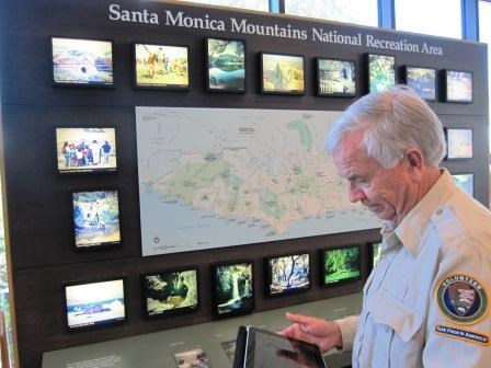 Ranger Burt looks up geocaches in the mountains while comparing them to the park map.
